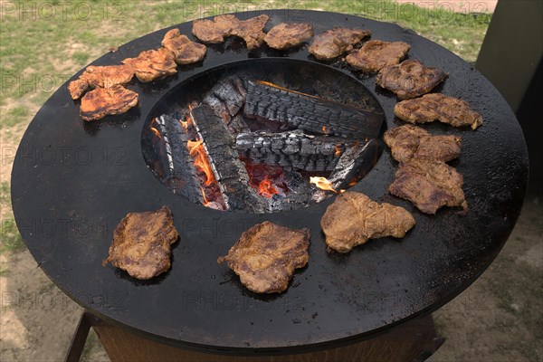 Ready-grilled pork steaks on an iron grill plate