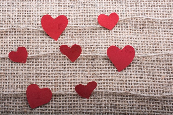 Love concept with heart shaped papers on linen threads