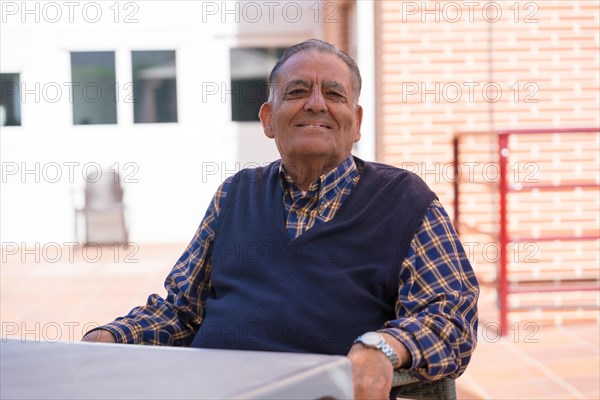 Portrait of an elderly man in the garden of a nursing home or retirement home on a sunny summer day