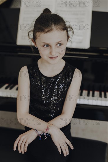 Girl sitting at the concert grand piano