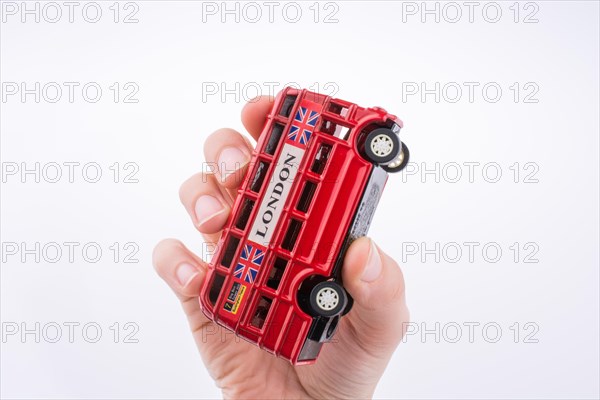 Hand holding a London double decker bus on a white background