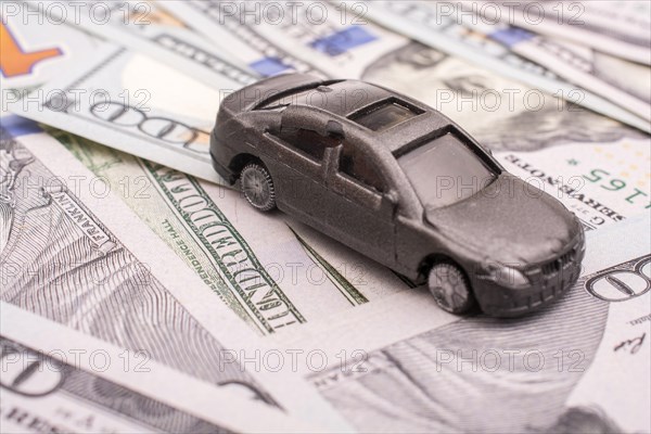 Model car placed US dollar banknotes spread on ground