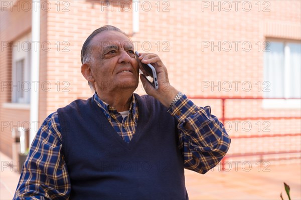 An elderly man in the garden of a nursing home or retirement home on a sunny summer day