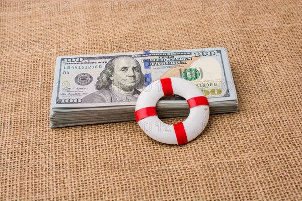 Life preserver placed on the banknote bundle of US dollar