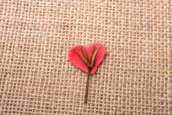 Heart shaped gold color metal object in hand