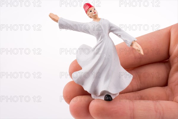 Hand holding a Sufi Dervis on a white background