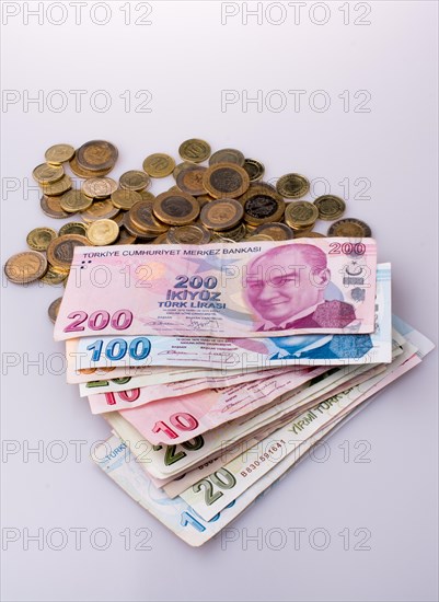 Turkish Lira coins and banknotes side by side on white background