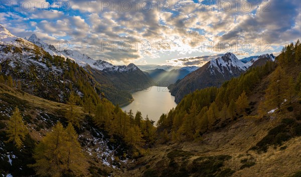 Aerial view at sunset over the autumnal forest at Lago di Luzzone in Valle di Blenio