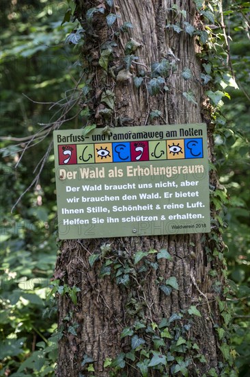Sign The forest as a recreational space on a tree stump on the Wuppenau barefoot path on the Nollen