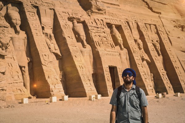 A young man wearing a blue turban visiting the Egyptian Temple of Nefertari near Abu Simbel in southern Egypt in Nubia next to Lake Nasser. Temple of Pharaoh Ramses II