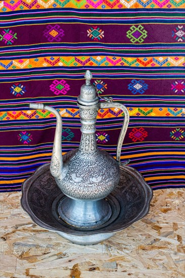 Ancient metal jug in oriental style in antique market