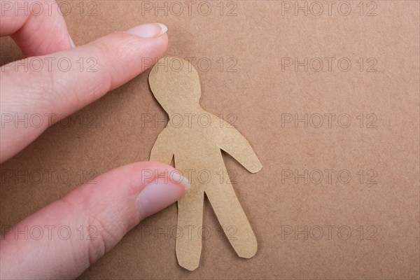 Man shape cut out of paper in hand in the view