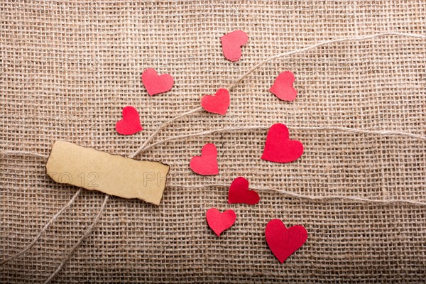 Love concept with heart shaped papers on linen threads