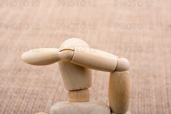 Wooden dolls of a man posing on canvas