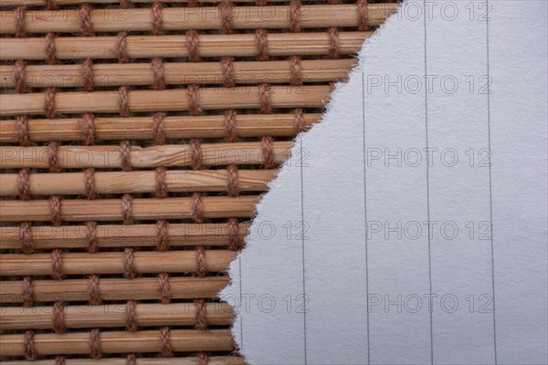 Piece of torn paper on a straw background