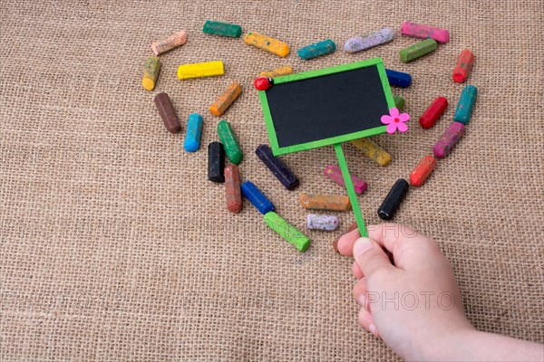 Notice board in the middle of crayons form a heart shape