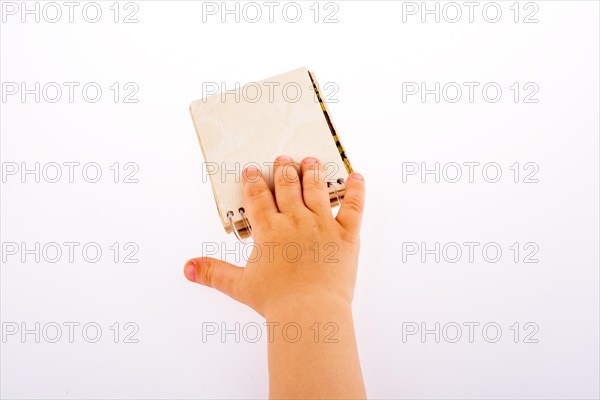 Baby holding a Spiral blank notebook on a white background