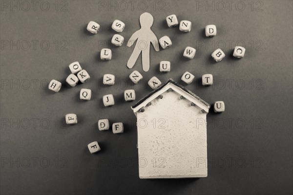 Wooden letter cubes and man figurine and model house