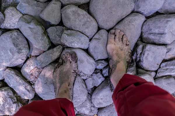 Feet of a man on stones on the Wuppenau barefoot path on Nollen