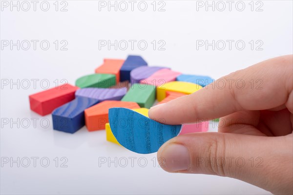 Colorful wooden pieces of a logic puzzle in hand