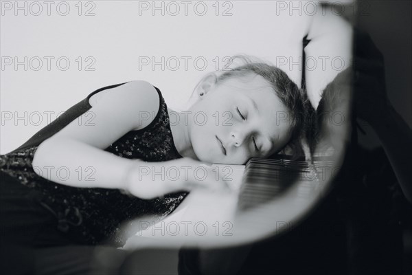 Elegant girl sits at the concert grand and plays the piano