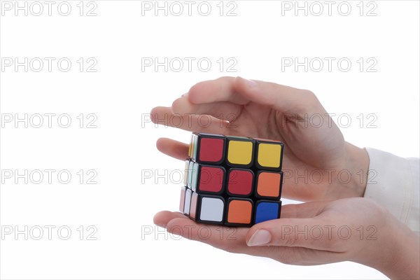 Child holding a Rubik's cube in hand on a white background