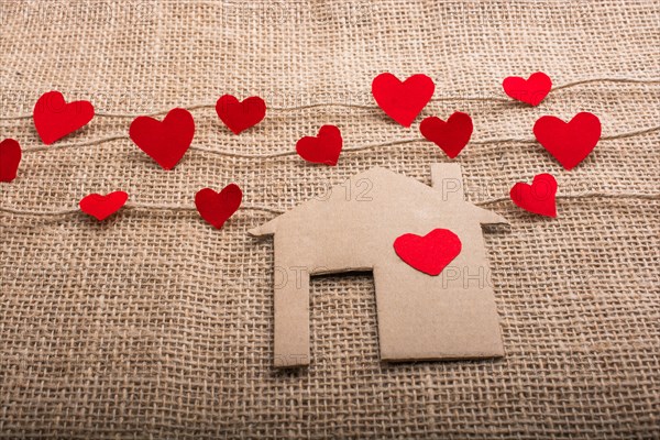 Heart shaped icons and paper house on linen threads