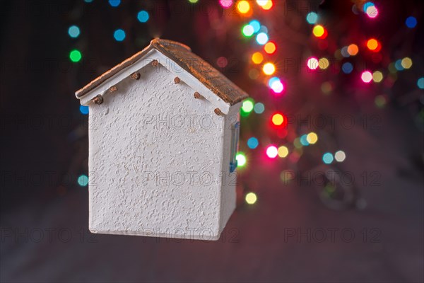 Little model house on a bokeh ligh ton a dark background