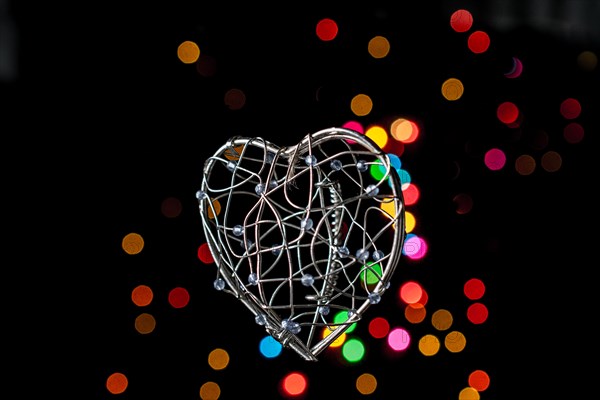 Heart shaped metal cage on a bokeh light background