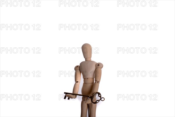 Puppet holding an antique golden key in hand on a white background