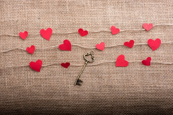 Love concept with heart shaped papers on linen threads