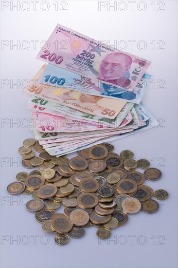 Turkish Lira coins and banknotes side by side on white background