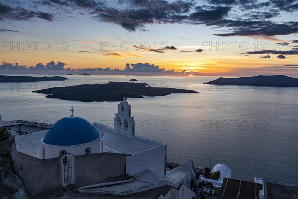 Sunset over the volcanic islands of Santorini and Anastasi Orthodox Church at sunset