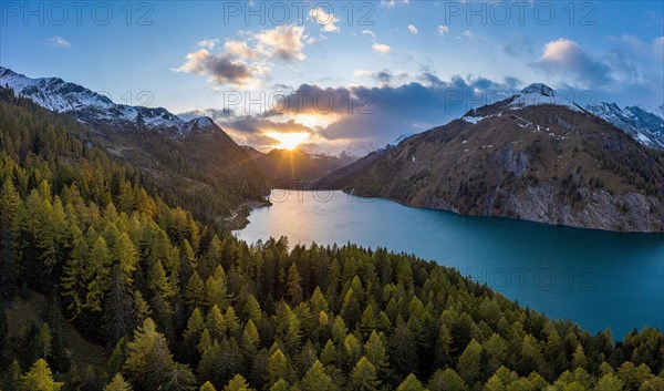 Aerial view at sunset over the autumnal forest at Lago di Luzzone in Valle di Blenio