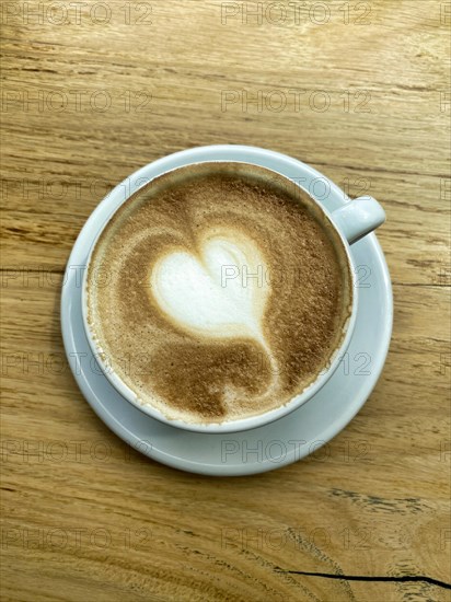 Cup of cappuccino with milk foam in the shape of a heart