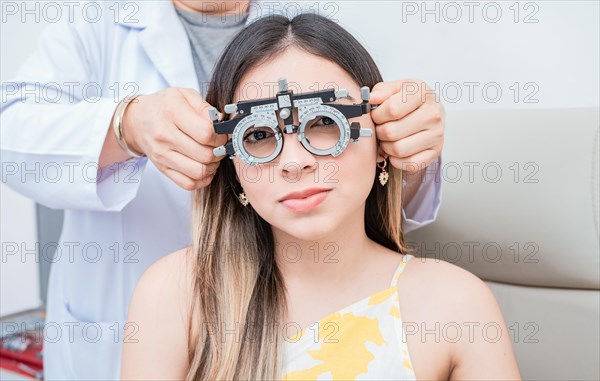 Hands of optometrist examining patient with optometrist trial frame. Young patient with optometrist trial frame