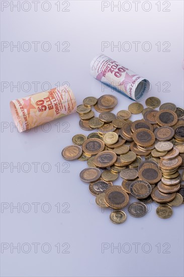 Turkish Lira coins and banknotes side by side on white background