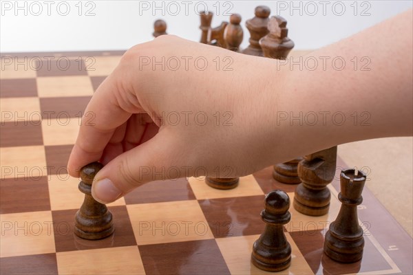 Person playing chess game making a move on board