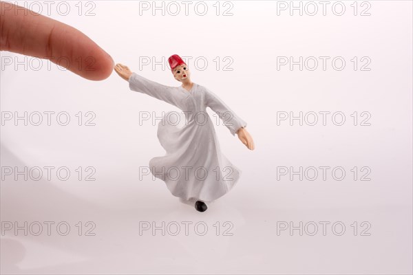 Hand holding a Sufi Dervis on a white background