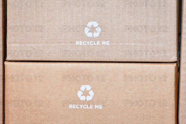 Cardboard boxes with recycling arrow symbol and text saying Recycle me