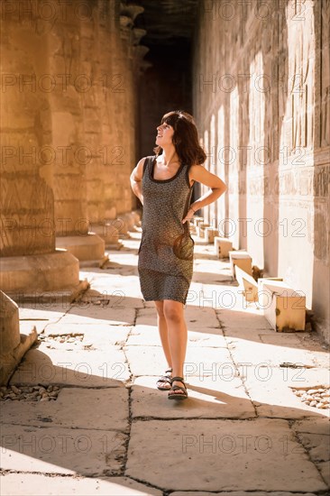 Portrait of a young brunette on the columns of the Edfu Temple near the city of Aswan. Egypt