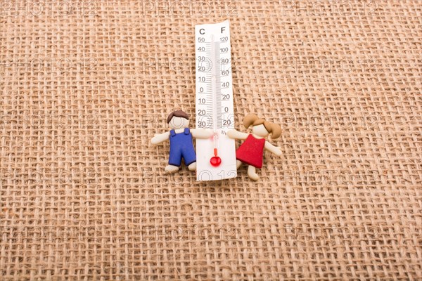 Thermometer placed between a boy and a girl figurine
