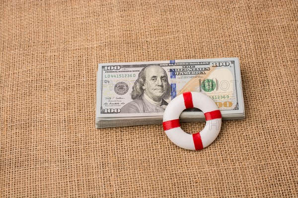 Life preserver placed on the banknote bundle of US dollar