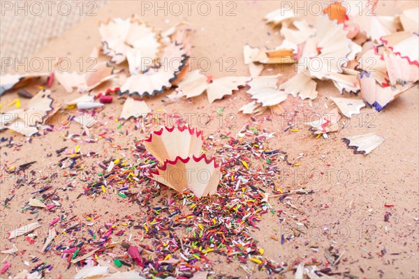 Colorful pencil shavings on a brown background