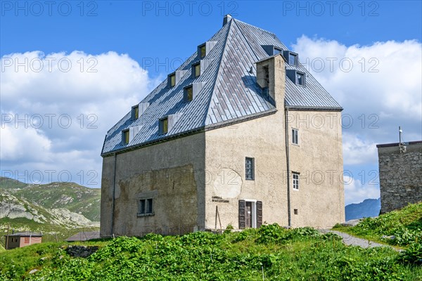 Rear view Side view with entrance to chapel in historic hotel accommodation Ospizio San Gottardo Saint Gotthard Hospice with historic building structure dating from 1237 13th century at 2091 metres high Gotthard Pass