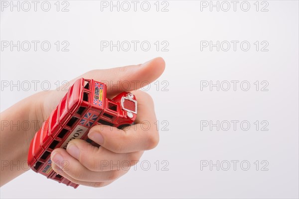 Hand holding a London double decker bus on a white background