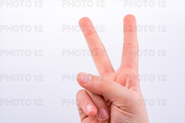 Hand making Victory Symbol on a white background