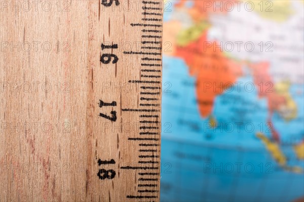 Model globe placed beside a wooden ruler