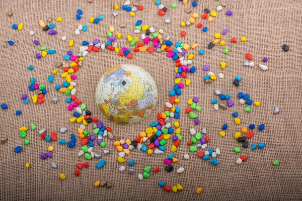 Globe in the heart form shaped by colorful pebbles