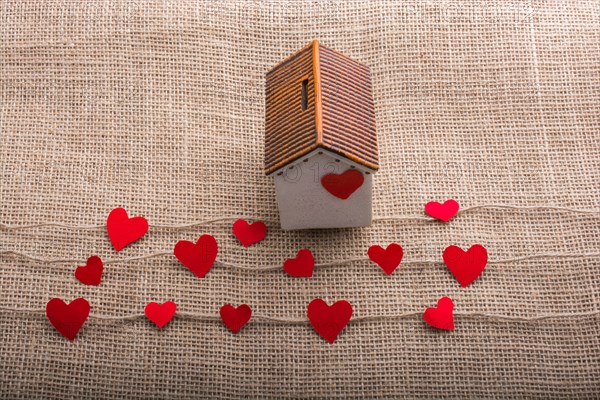 Heart shaped icons and paper house on linen threads